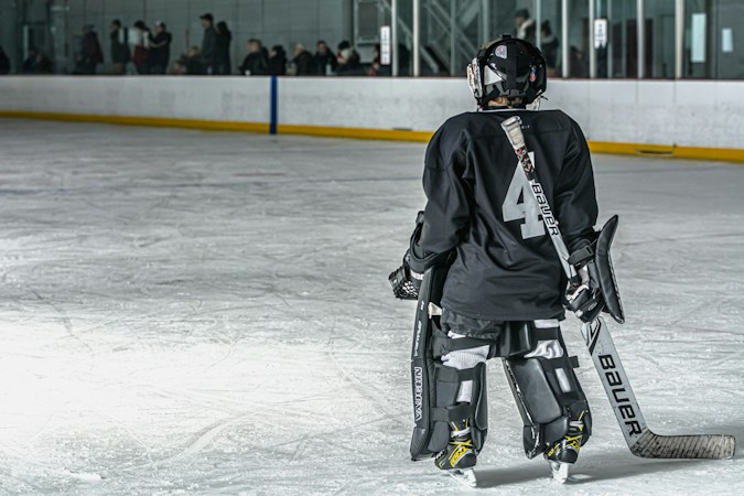 A hockey goalie in full pads stands alone on a practice rink, like the players fighting for roster spots in Golden Knights training camp