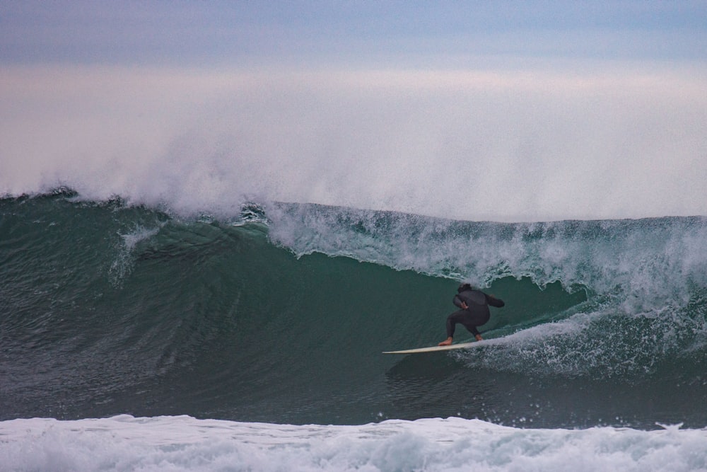 a man riding a wave on top of a surfboard