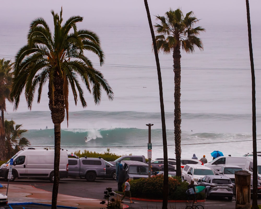 a parking lot filled with lots of cars next to the ocean