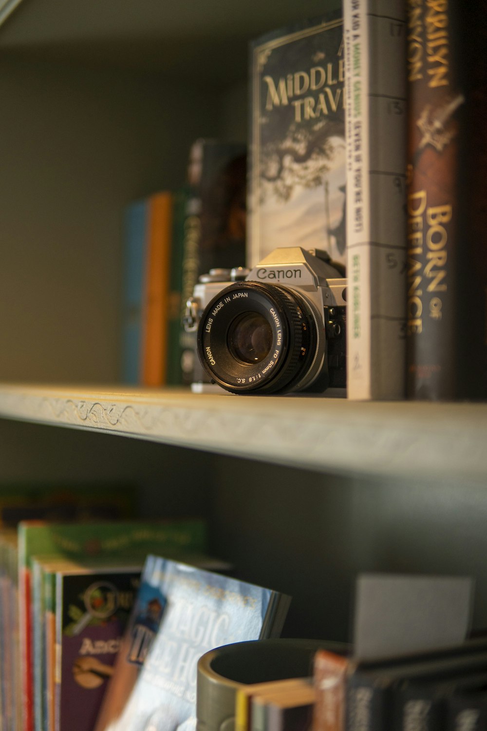 a camera sitting on top of a book shelf