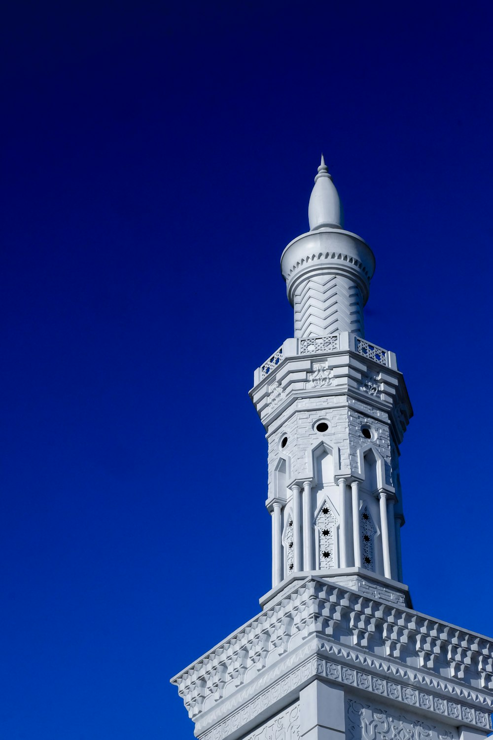 a tall white tower with a clock on it's side