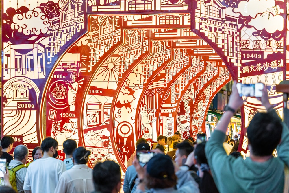 a group of people standing in front of a large mural