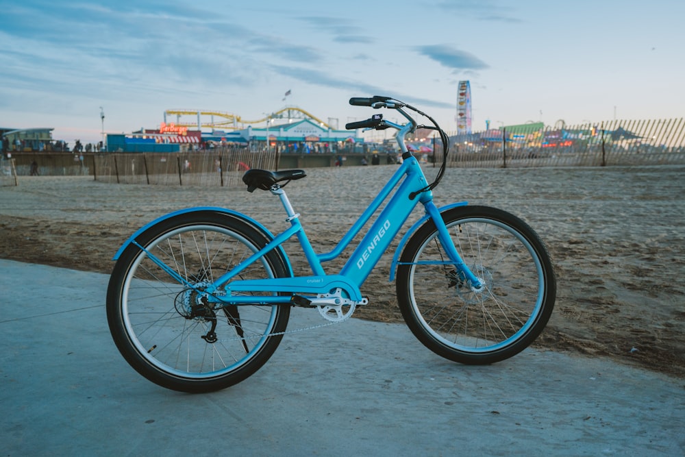 una bicicleta azul estacionada al costado de la carretera