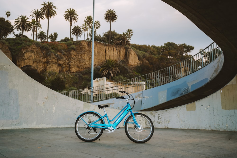 a blue bicycle parked in front of a wall