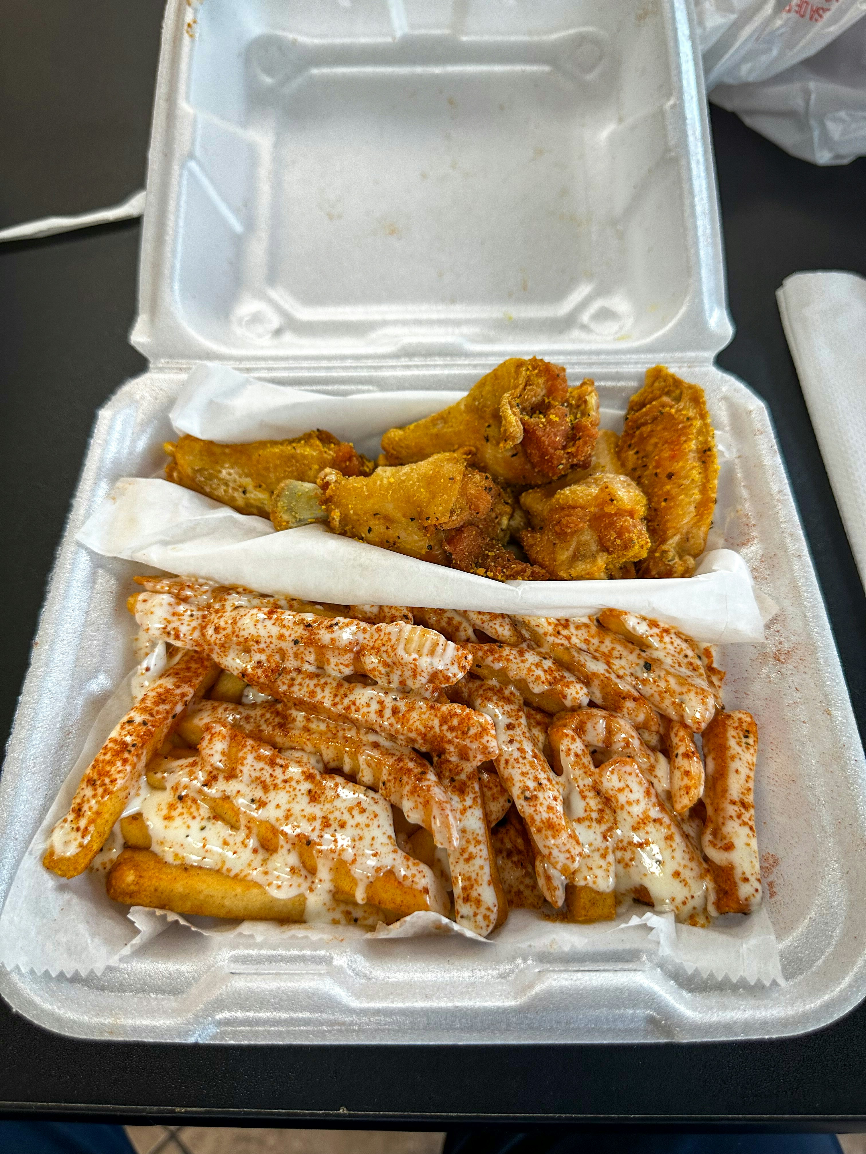 Alitas Frisby: doce alitas de pollo crujientes doradas con salsa BBQ en tazón con papas fritas al lado