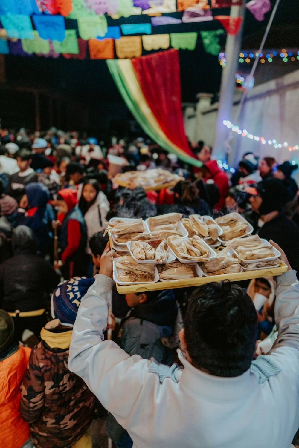 a man carrying a tray of food over his head