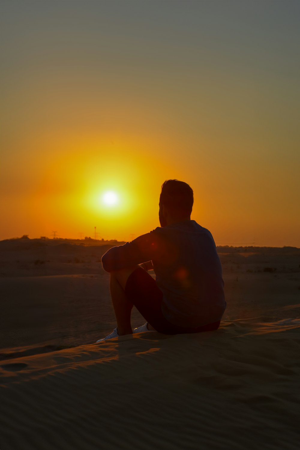 a man sitting on top of a sandy beach