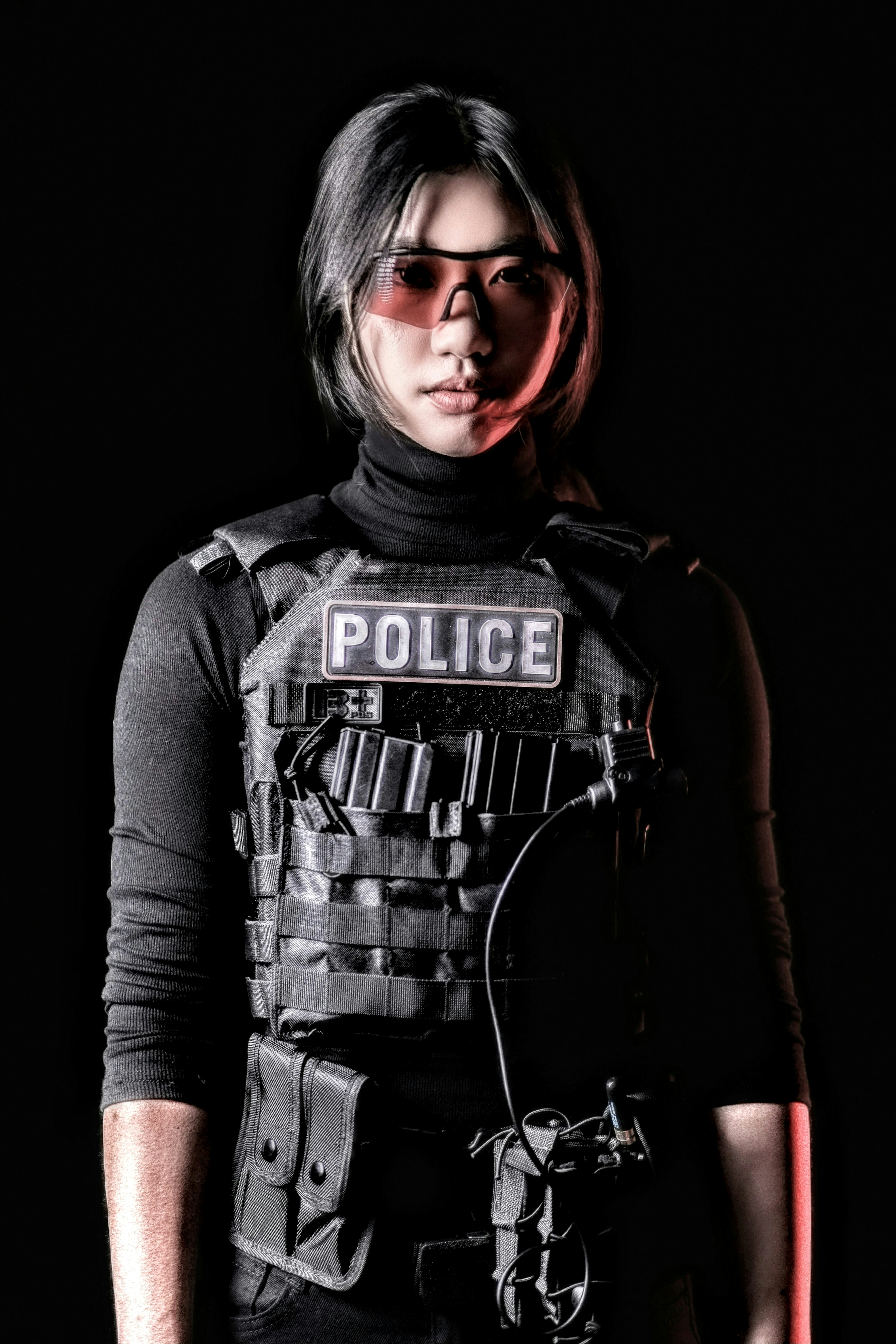 a woman wearing a police vest and glasses