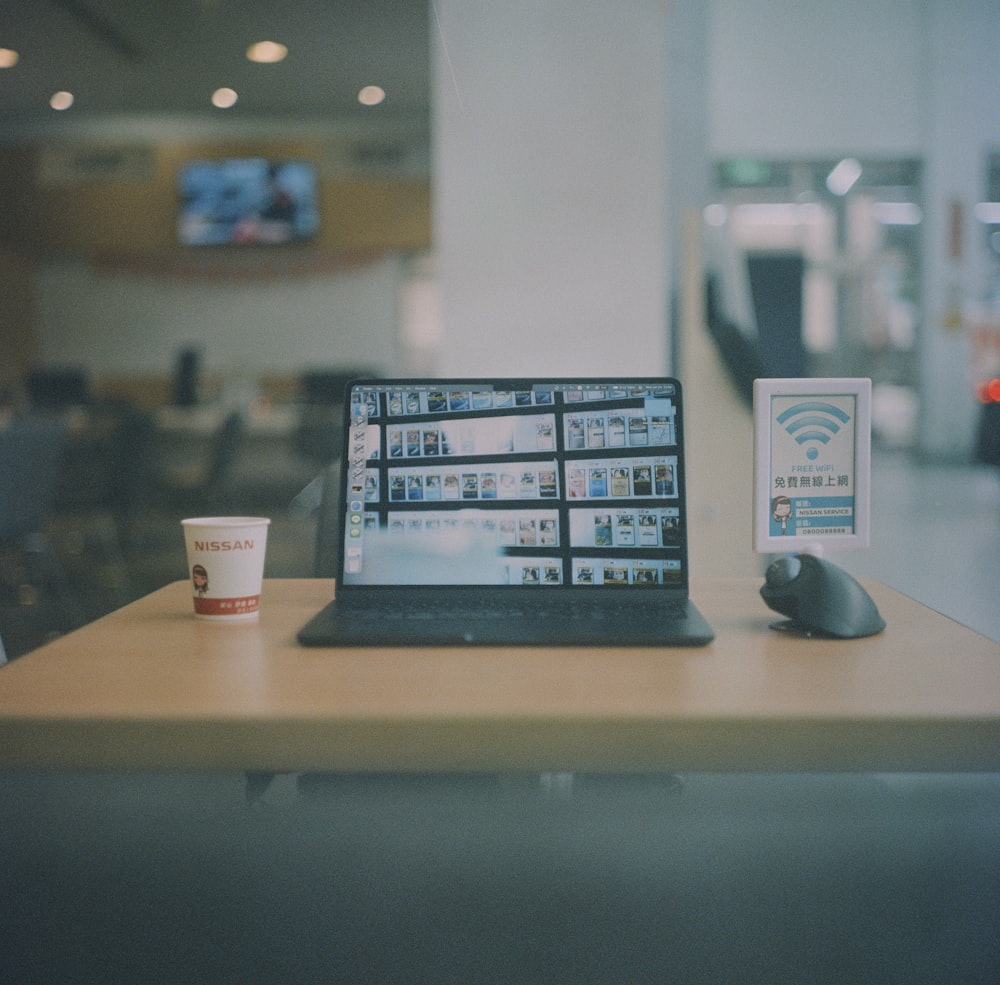 a laptop computer sitting on top of a wooden table