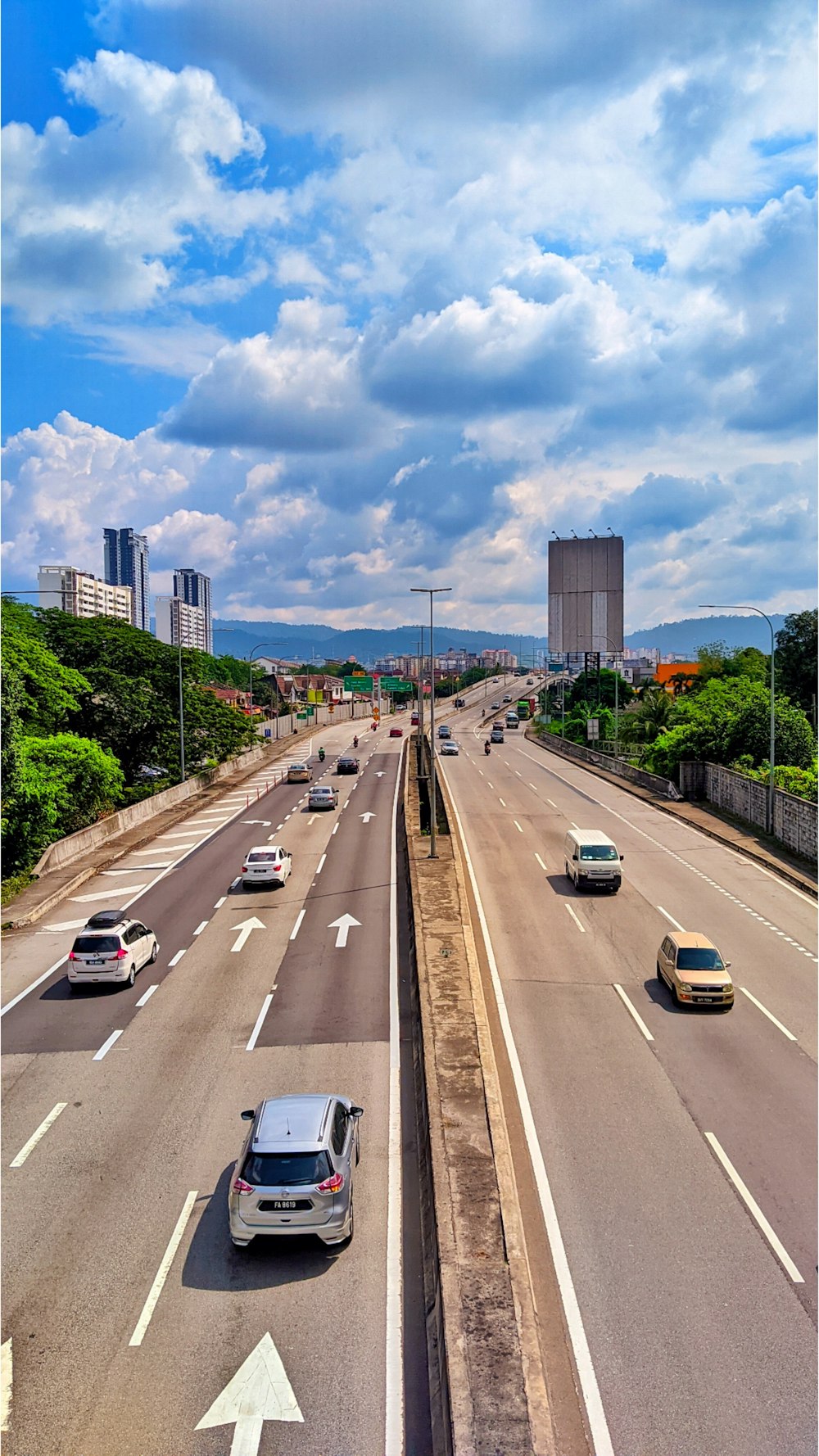 cars driving down a highway with a sky background