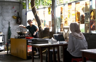 a woman standing in a kitchen next to a tree