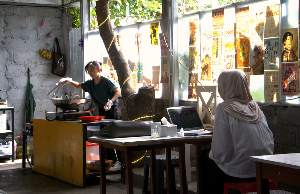 a woman standing in a kitchen next to a tree