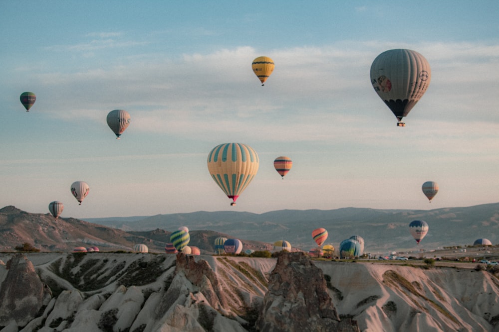 a group of hot air balloons flying over a mountain