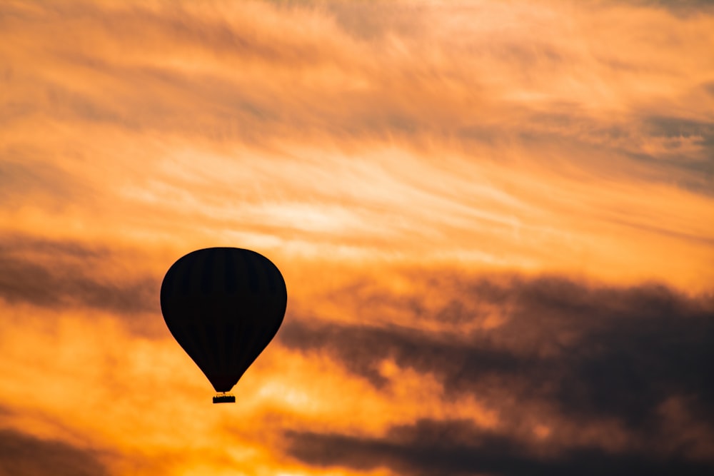 a hot air balloon flying through a cloudy sky