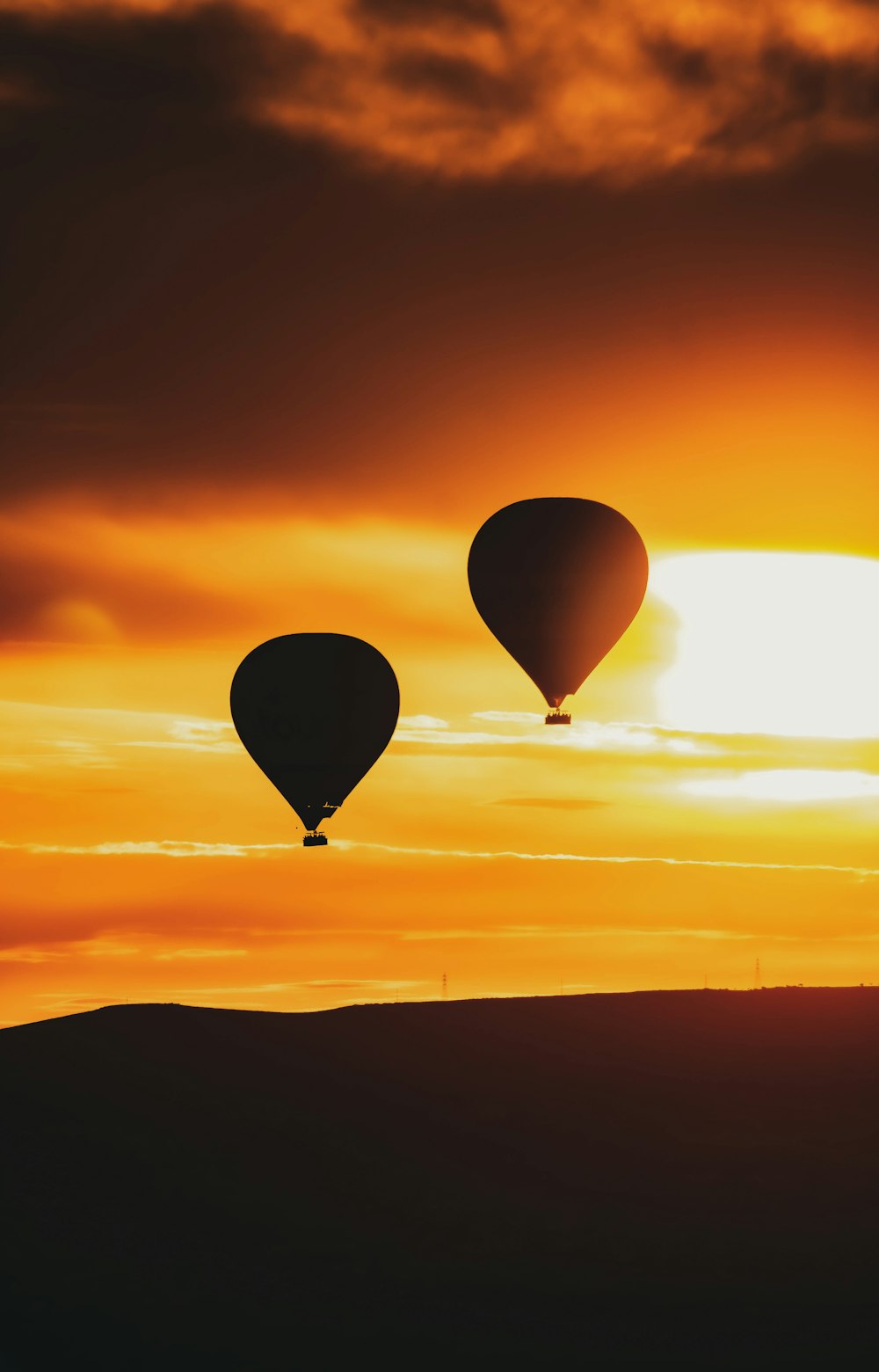 a couple of hot air balloons flying in the sky