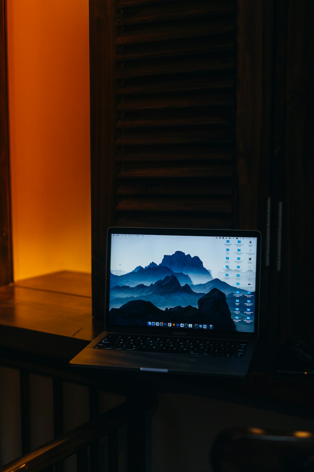 a laptop computer sitting on top of a wooden desk