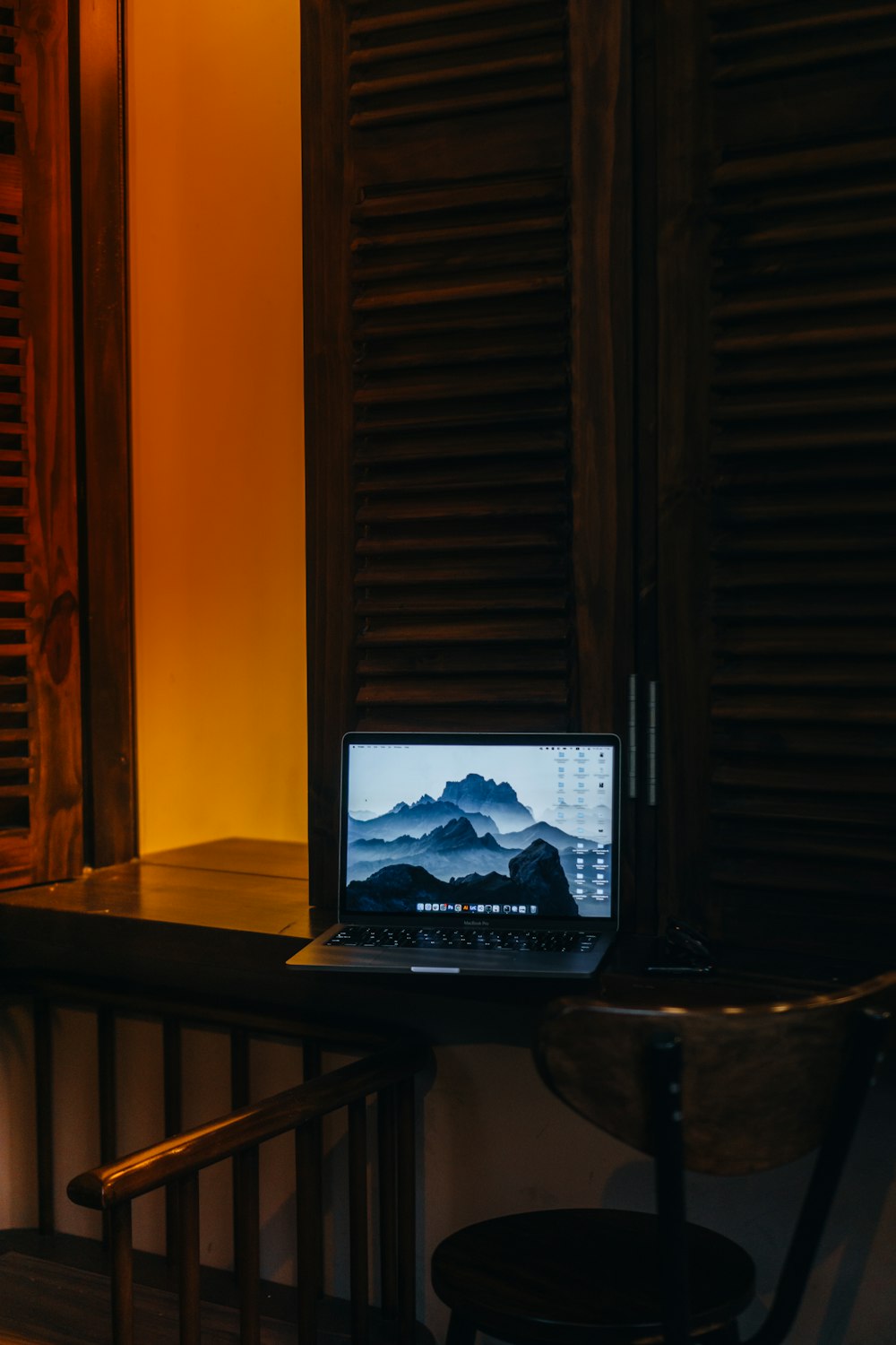 a laptop computer sitting on top of a wooden desk