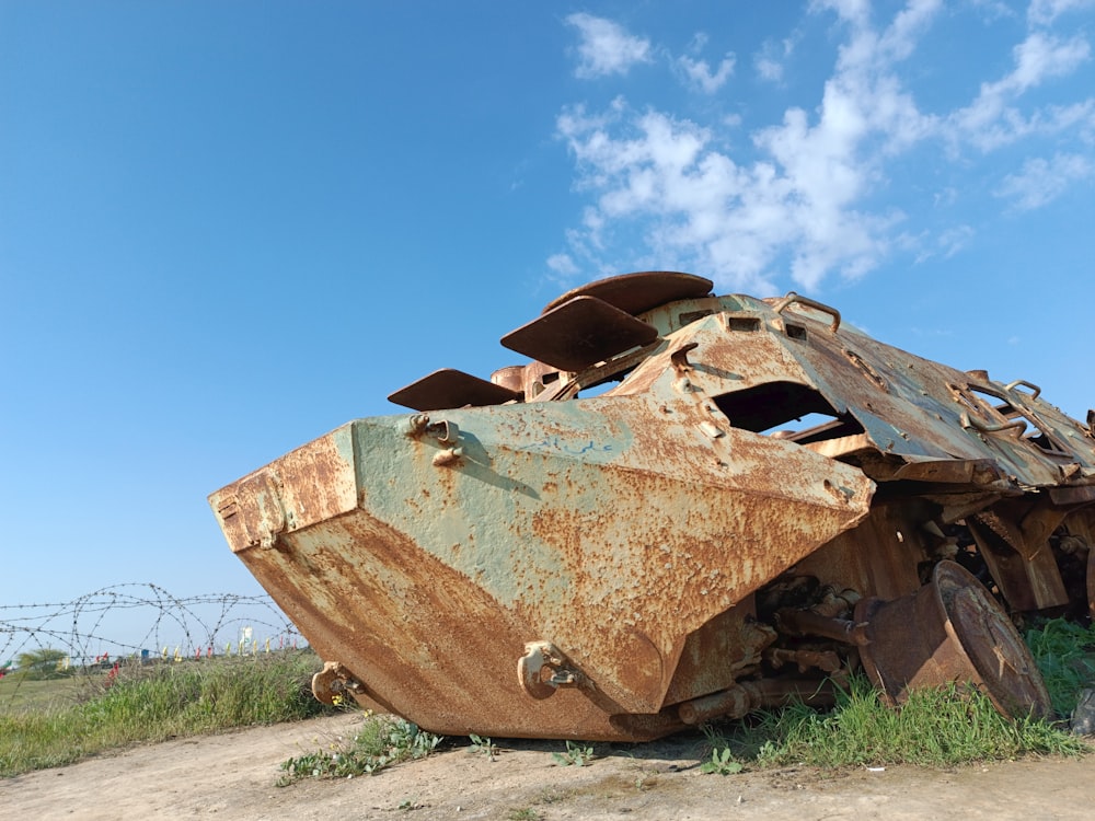 an old rusted out vehicle sitting in a field