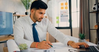 a man sitting at a desk working on a laptop