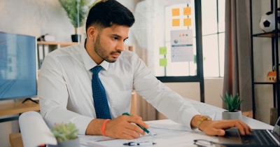 a man sitting at a desk working on a laptop