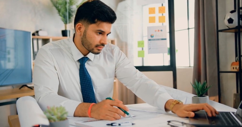 a man sitting at a desk working on a laptop