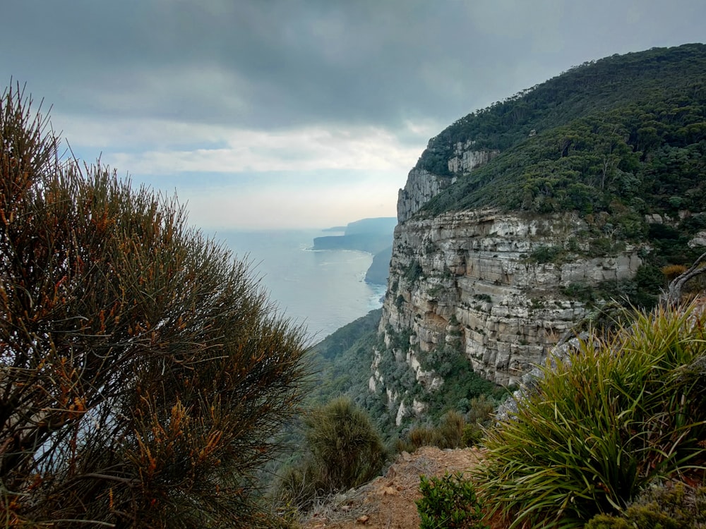 a view of a cliff with a body of water in the background