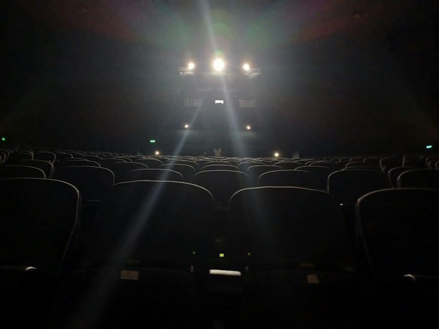 Une grande salle de cinéma vide, aux rangées de fauteuils tournées vers un écran géant