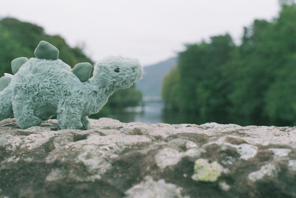 a stuffed animal is sitting on a rock