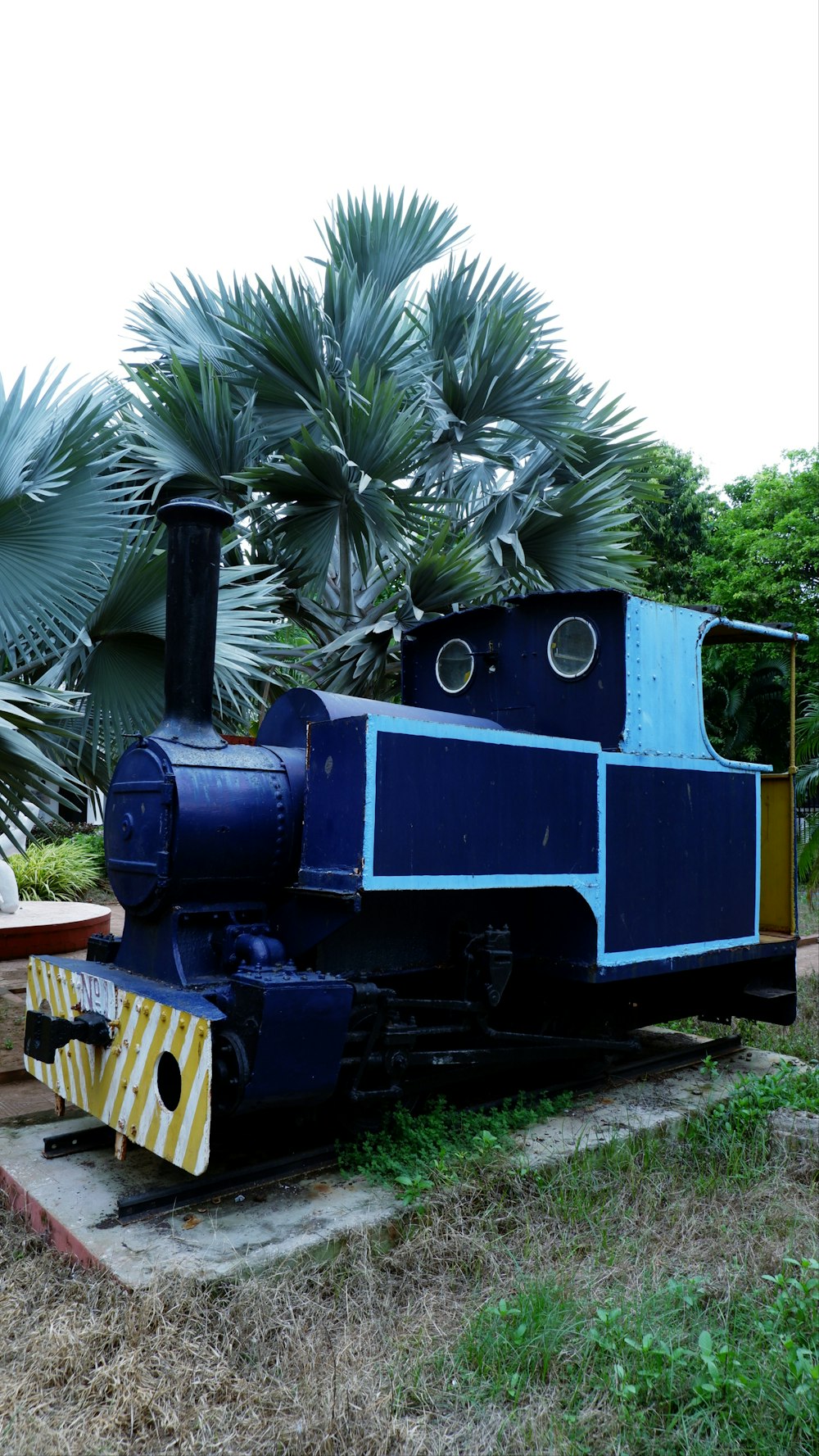 a blue and yellow train sitting on top of a train track