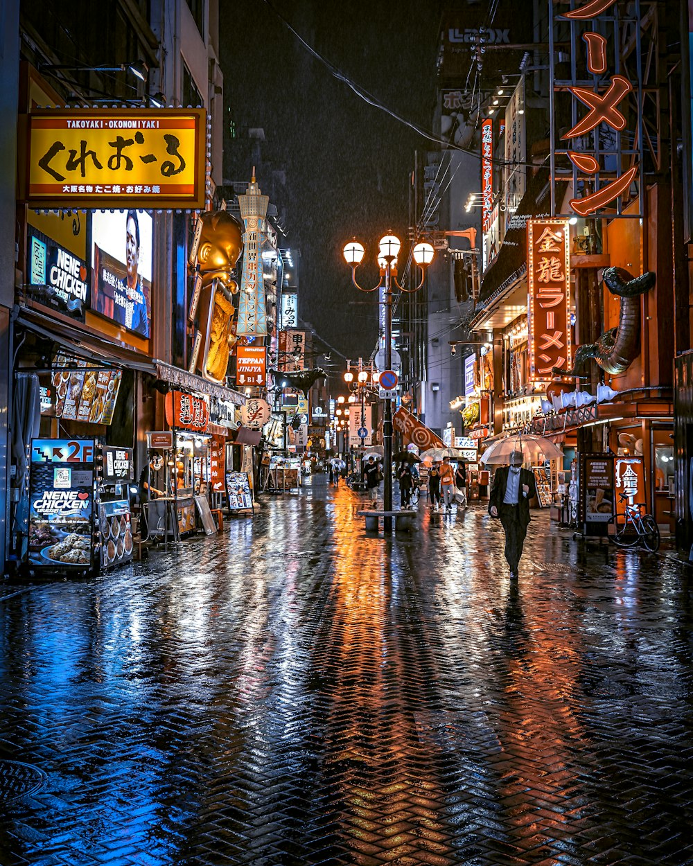 a person walking down a wet street at night