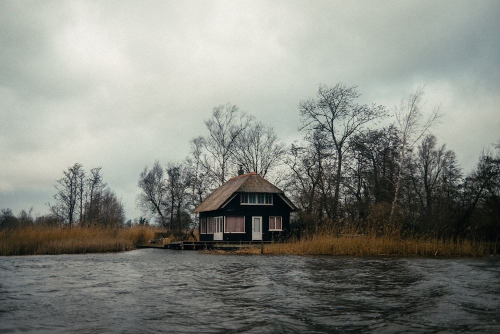 uma casa sentada à beira de um corpo de água
