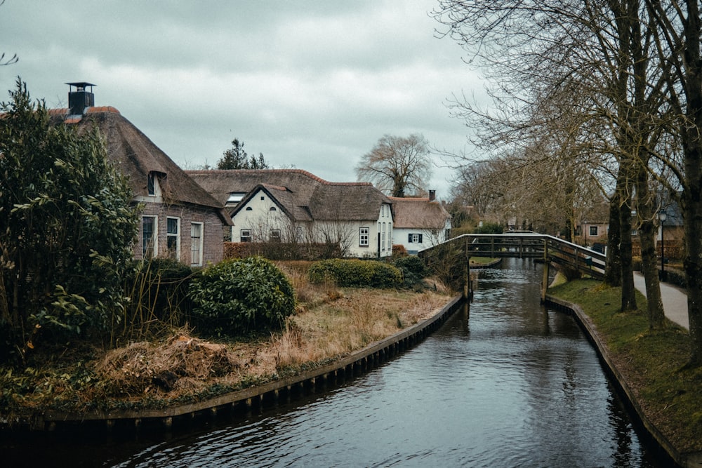 a river running through a small village next to a bridge