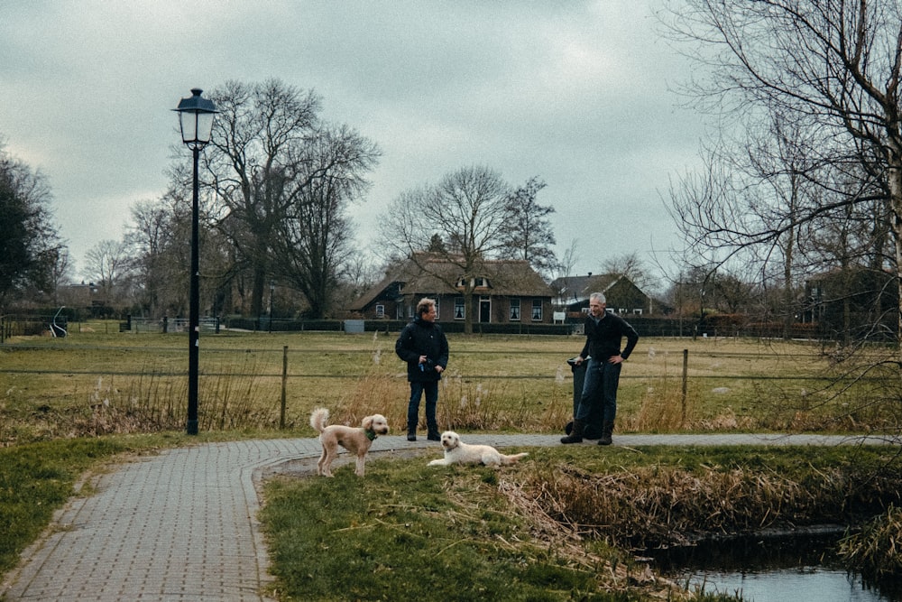 a couple of men standing next to a dog