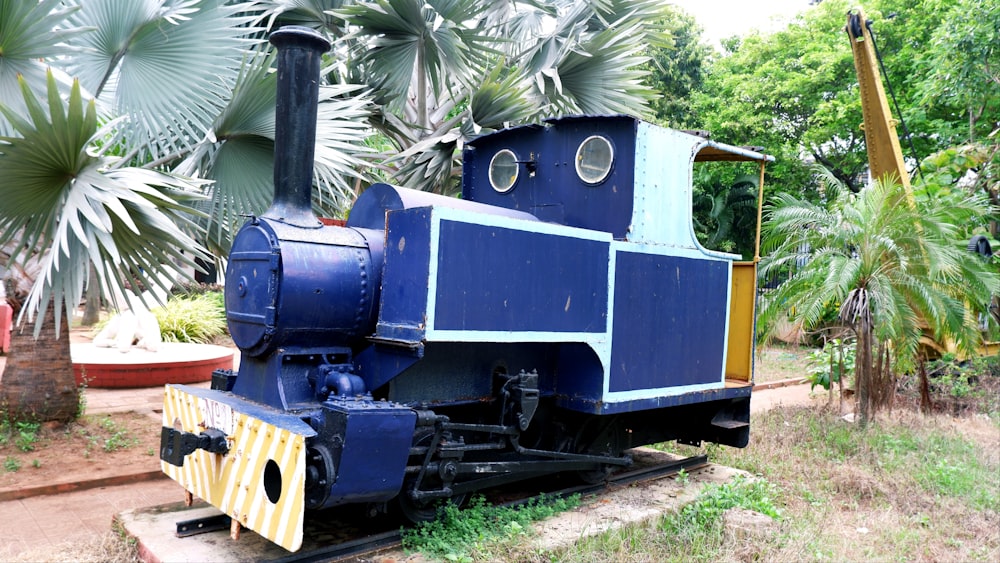 un tren azul y amarillo sentado en la parte superior de una vía de tren