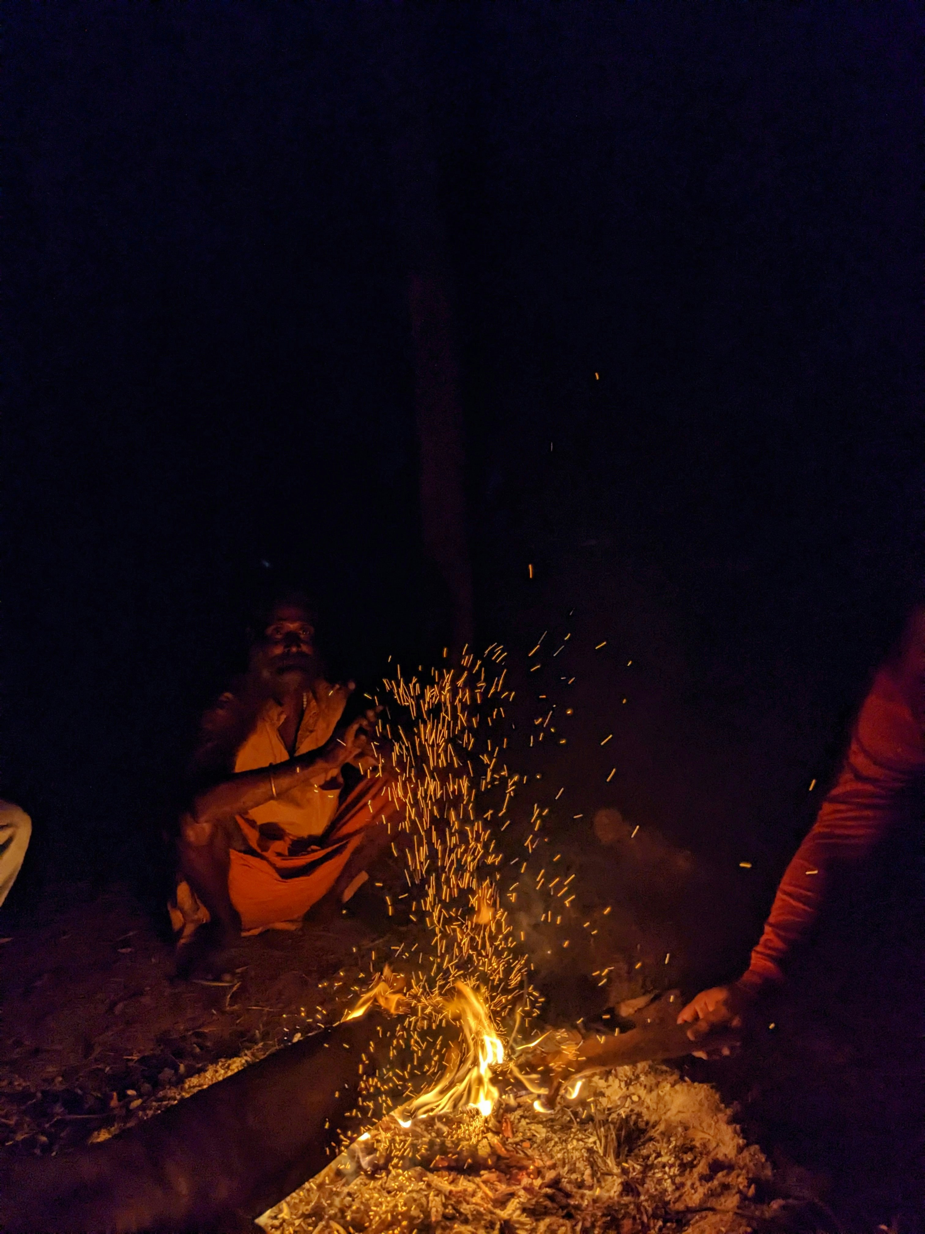 A group of women sitting around a campfire.