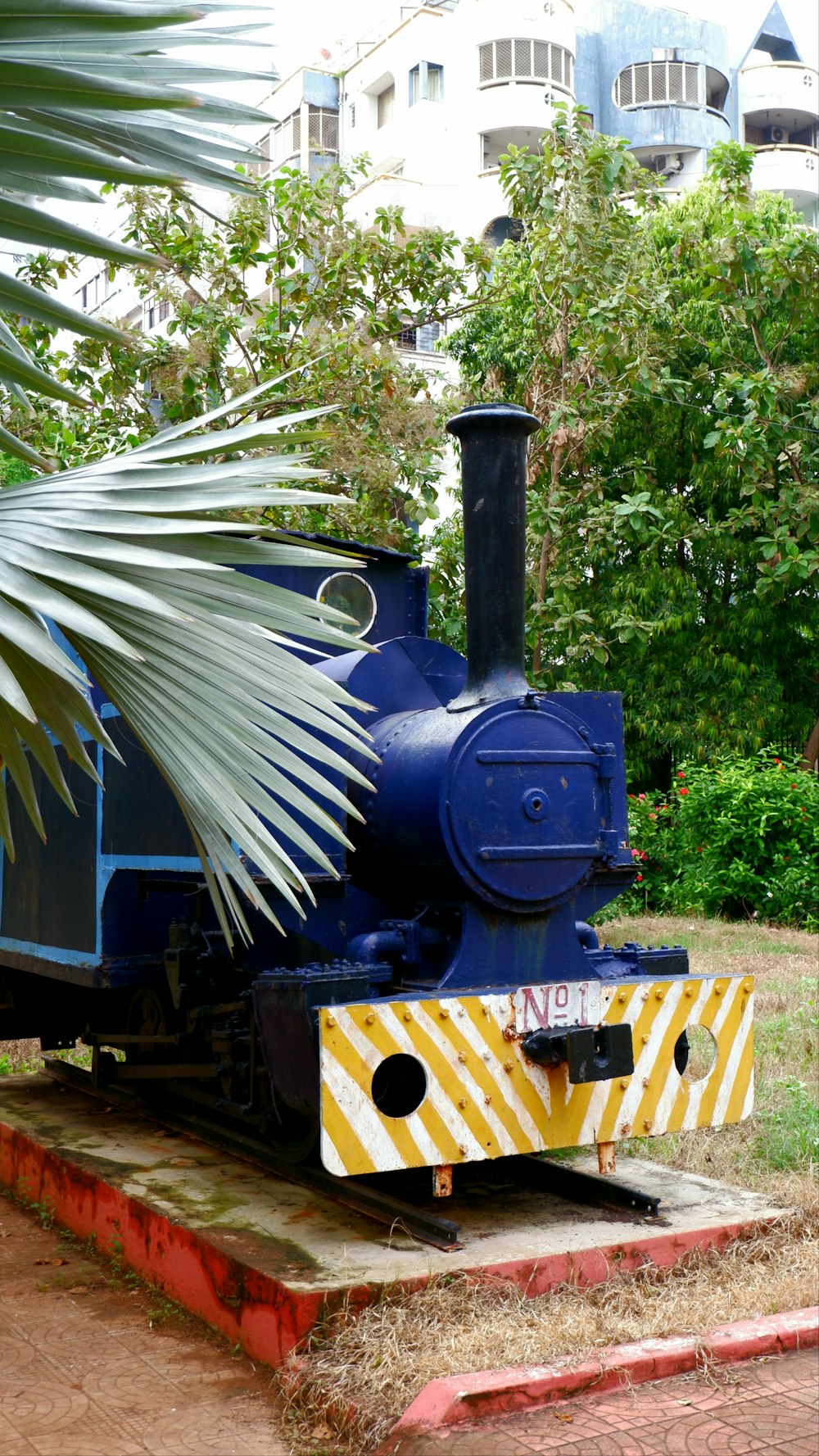 um trem azul sentado em cima de um trilho de trem