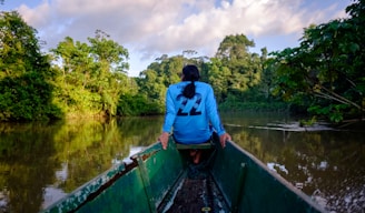a woman sitting in a boat on a river