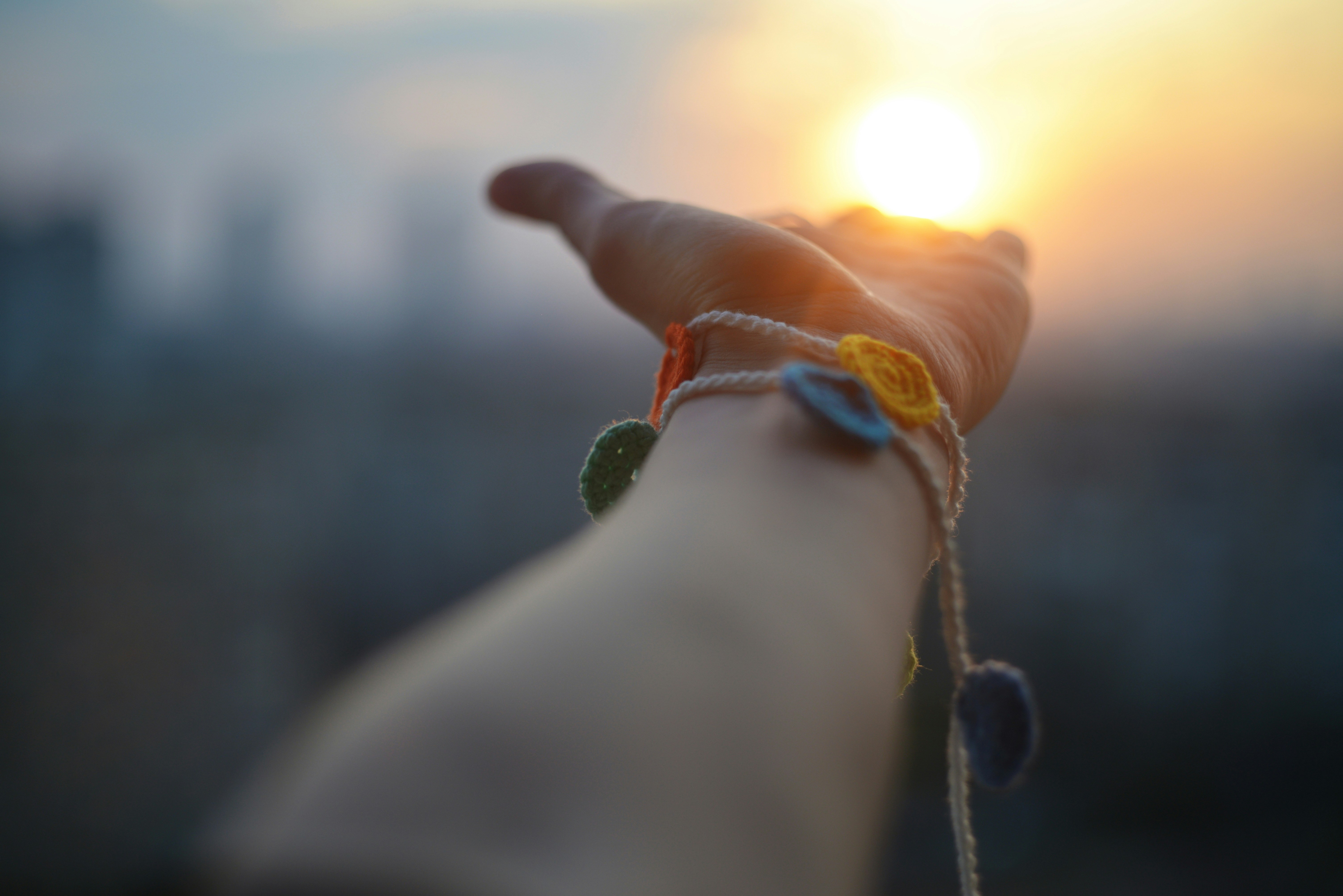 A hand holding a string with a sunset in the background photo – Free ...