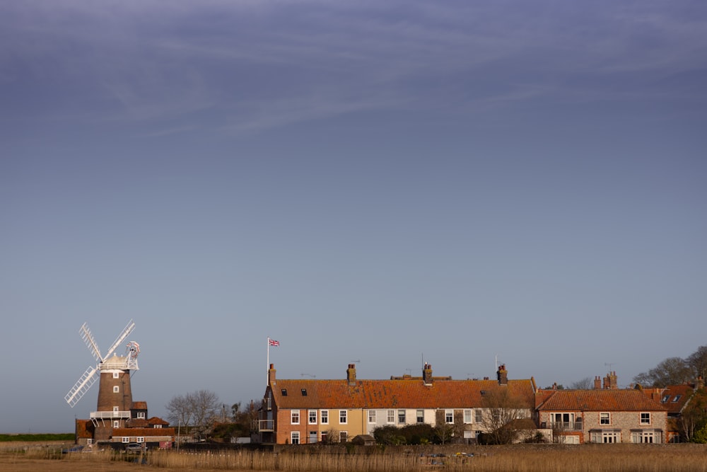 a windmill in a field next to a building