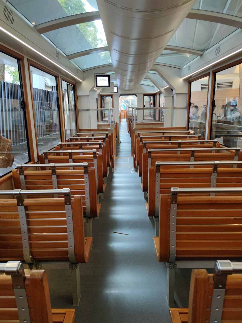 a long row of wooden benches sitting inside of a building