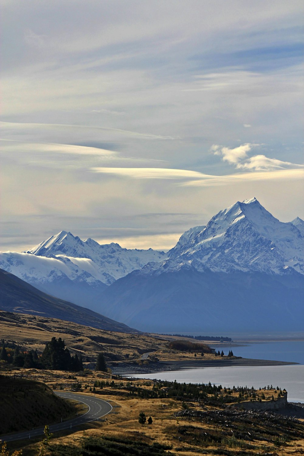 a scenic view of a mountain range with a lake in the foreground