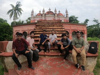 a group of men sitting on top of a stone structure