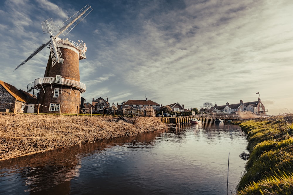 a windmill sitting on the side of a river