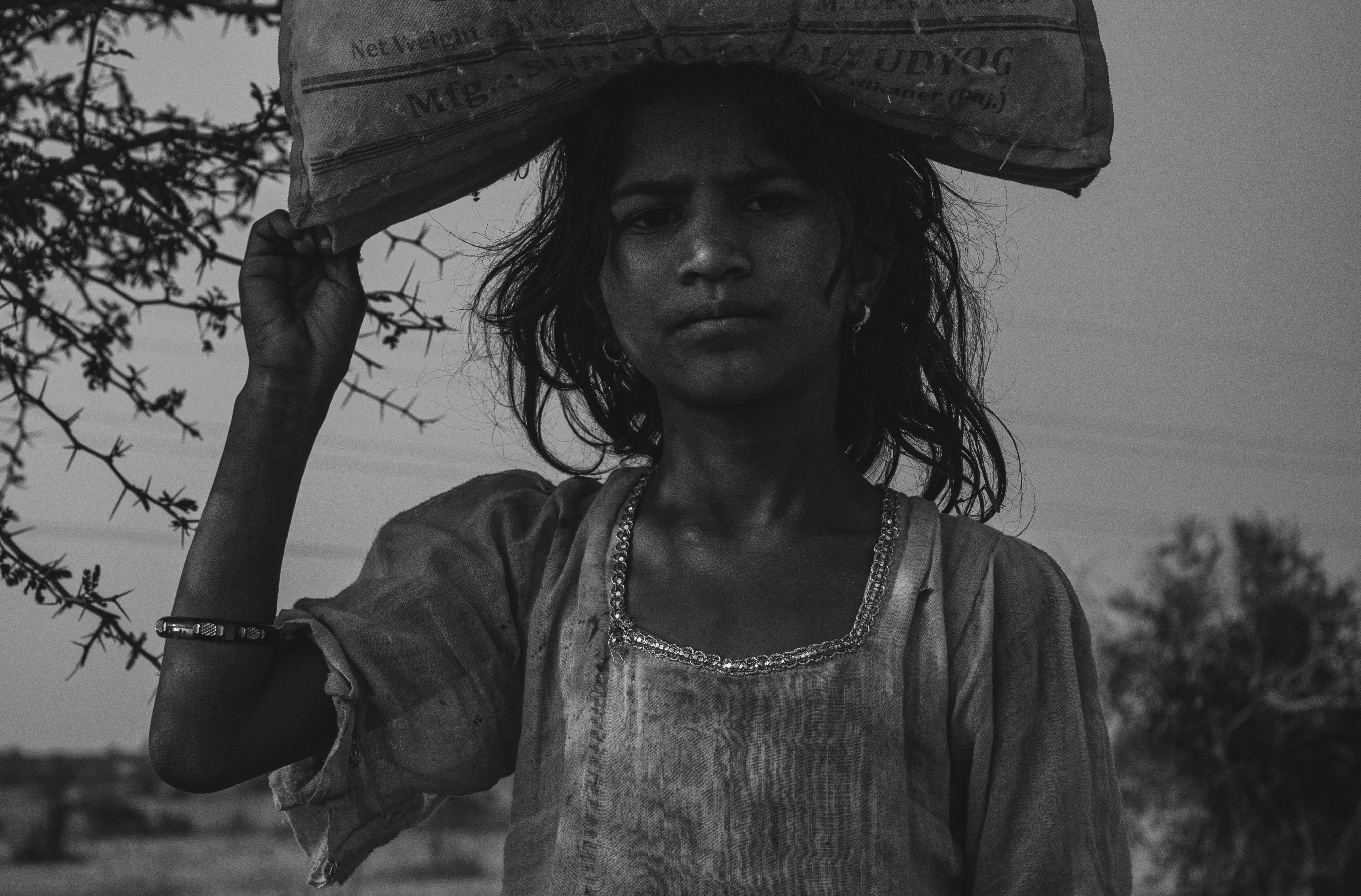 a woman carrying a large bag on her head