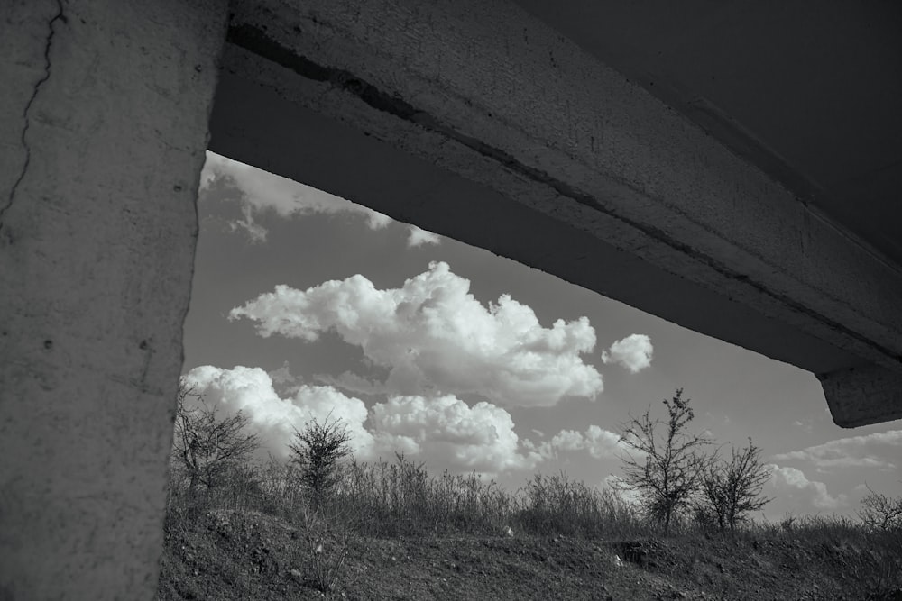 a black and white photo of clouds over a field