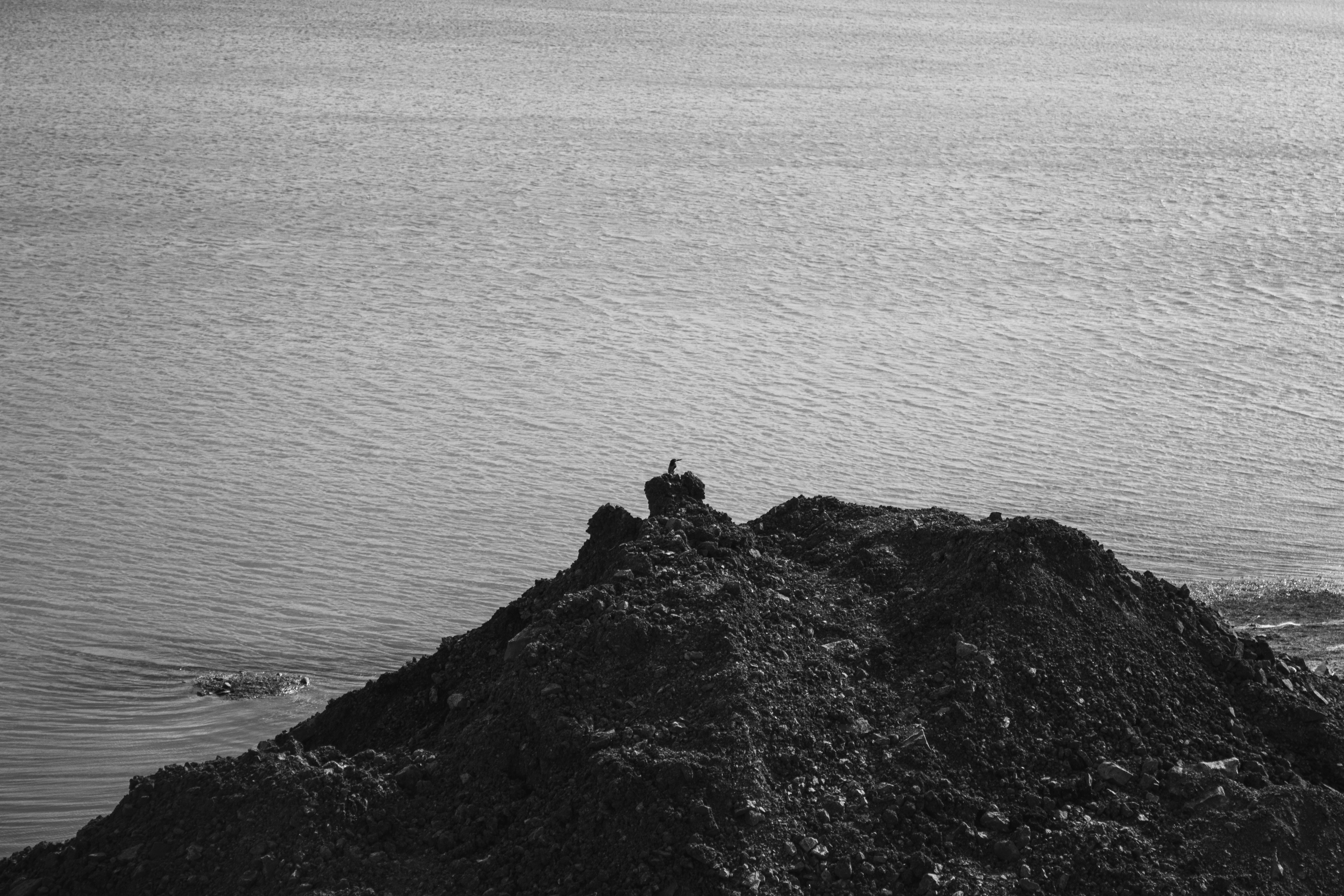 une photo en noir et blanc d’une personne assise sur un rocher