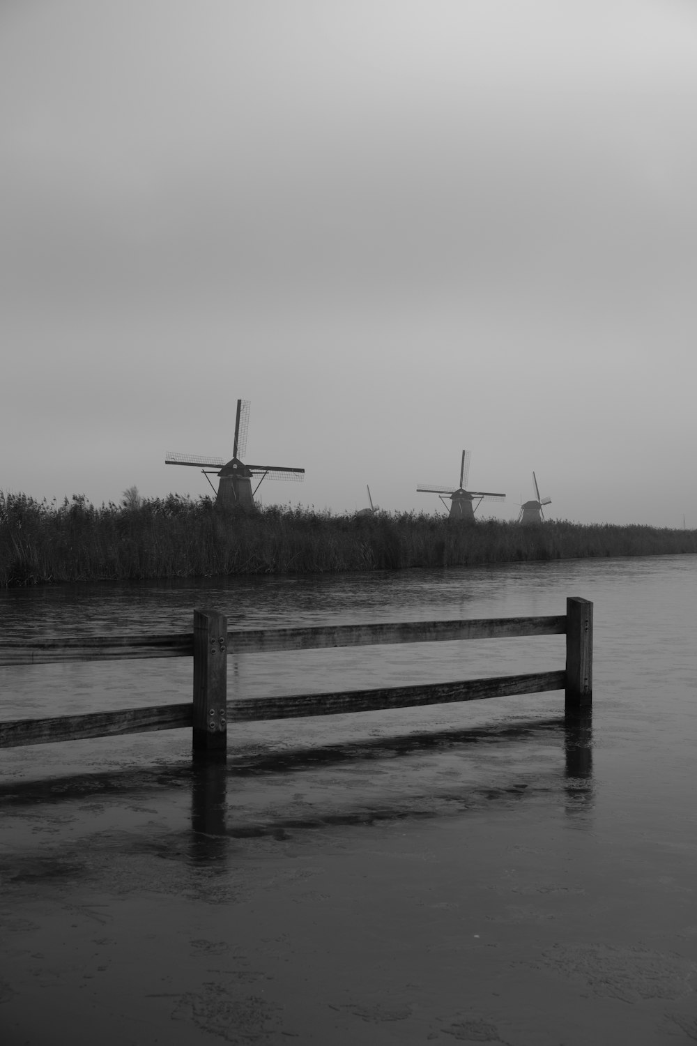 une photo en noir et blanc de trois moulins à vent