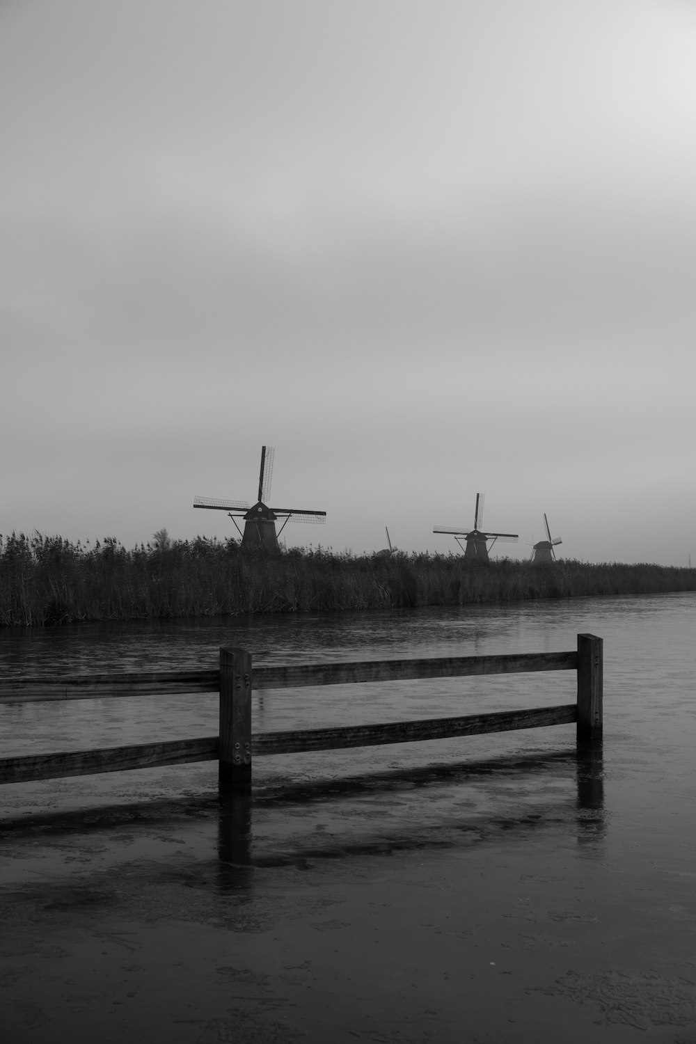 a black and white photo of three windmills
