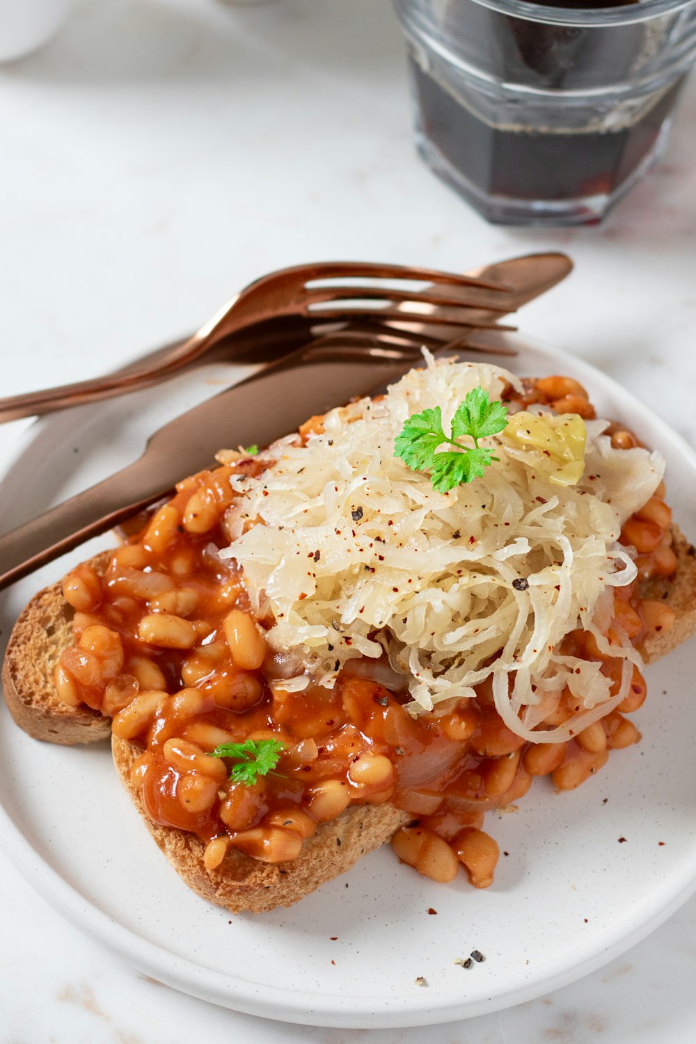 un plato blanco cubierto con un trozo de pan cubierto de frijoles