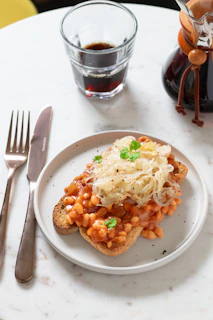 a white plate topped with a piece of toast covered in beans